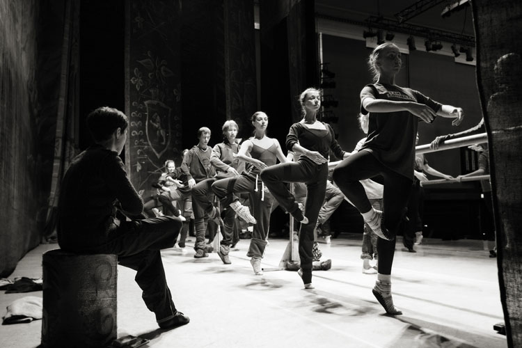 A black and white image of ballerinas at the barre on stage at The Colosseum in Watford