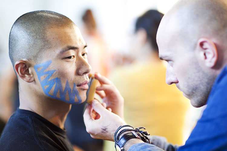 A make-up artist testing make-up on a cast member