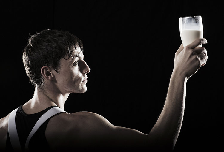 Martin McCreadie holds a glass of milk in a promotional image for the Soho Theatre