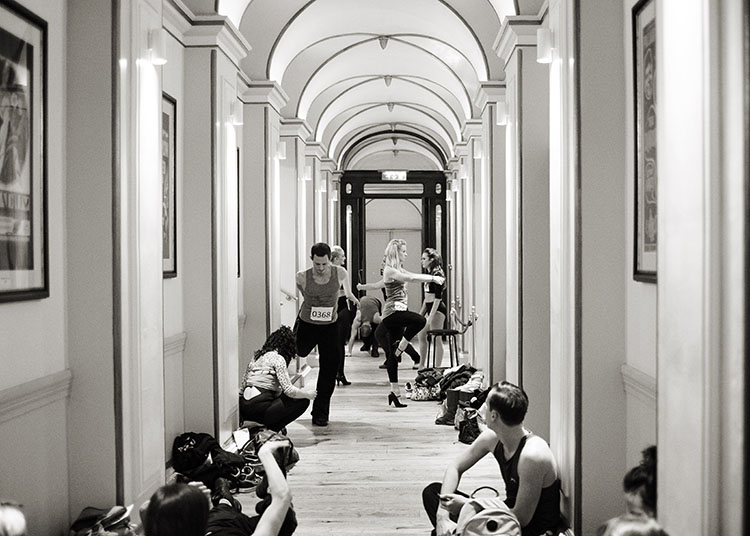 A black and white photo of dancers warming up at the London Palladium