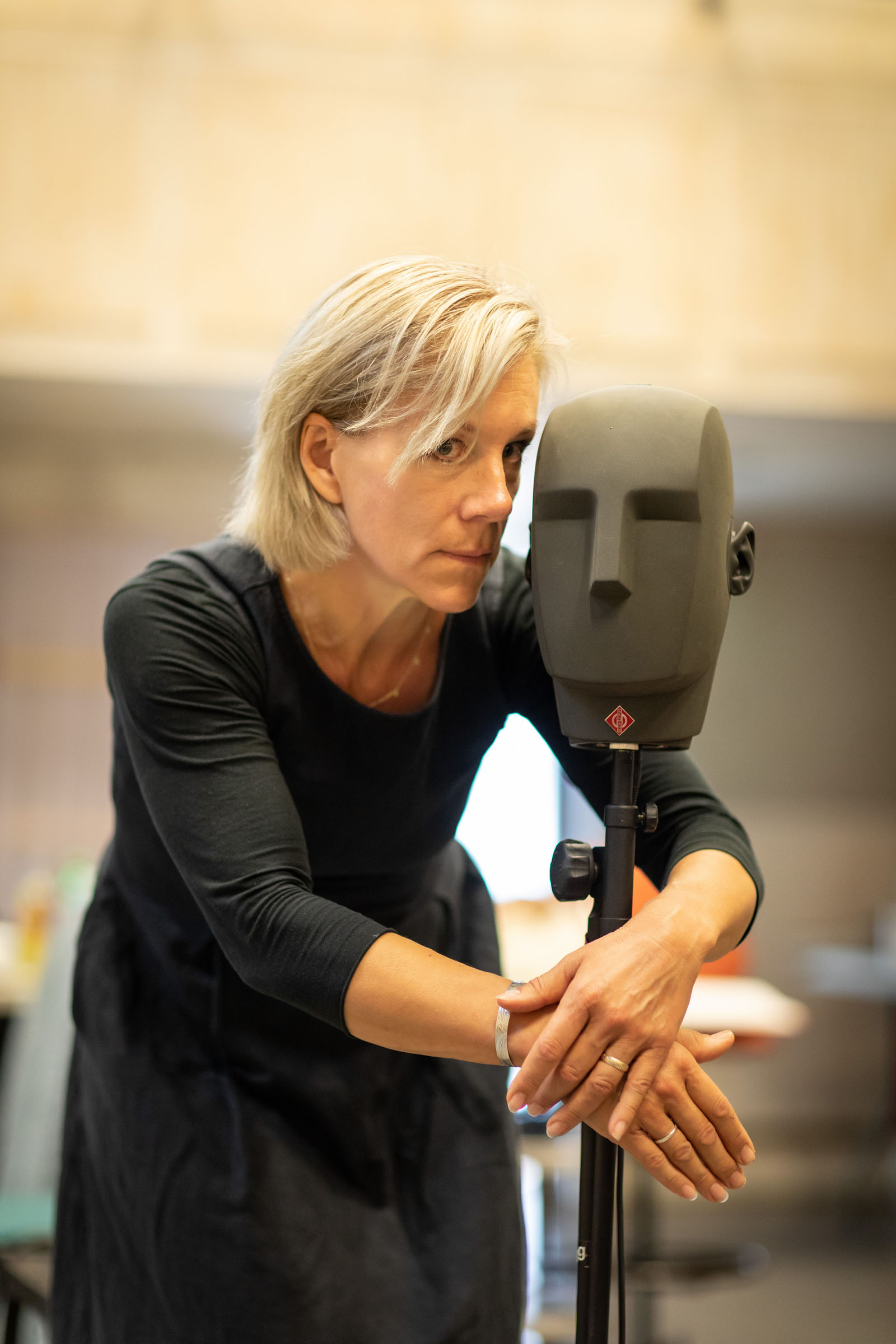 Juliet Stevenson with her hand wrapped around a binaural recording device